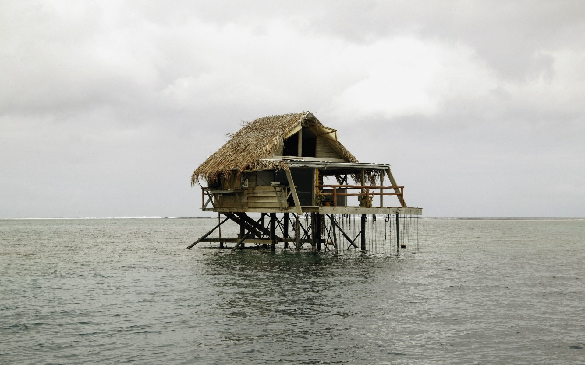 house on the water thatched roof hut building water islands surface nature landscape house horizon bad weather the gray sky overcast