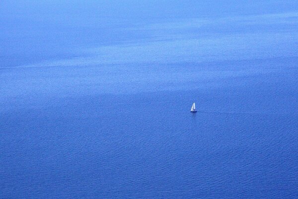 A lonely sailboat in the blue sea