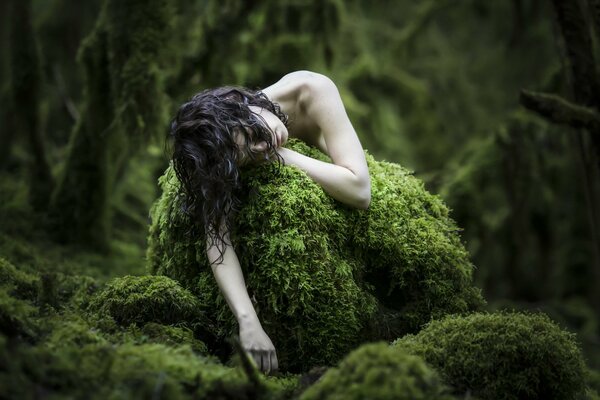 Pale girl in the forest on moss