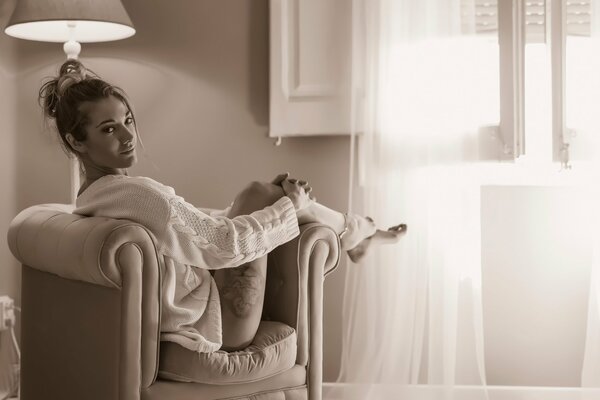 A girl in a chair with a tattoo on her hip