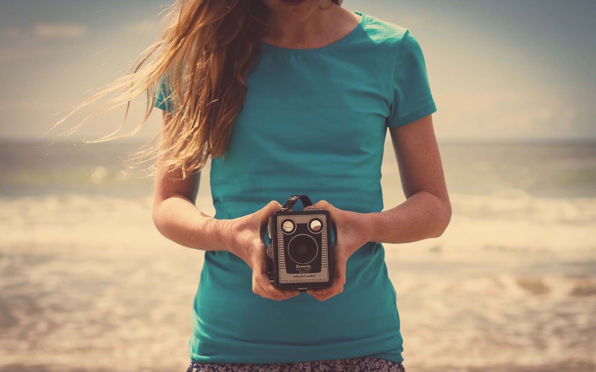 mood girl brown hair nature beach sand hands a camera the camera background . wallpapers hd wallpaper