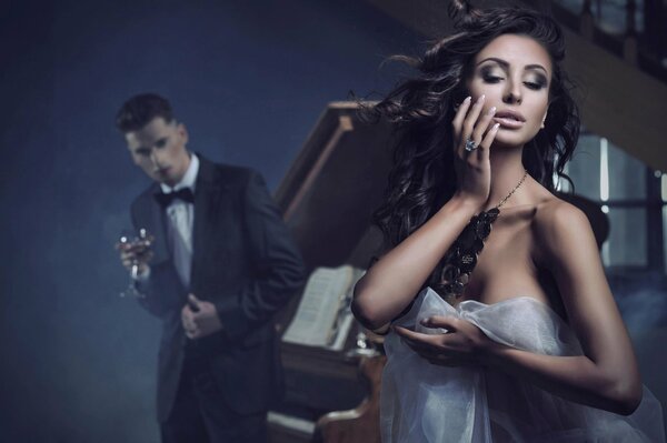 Sexy woman and man standing at the piano