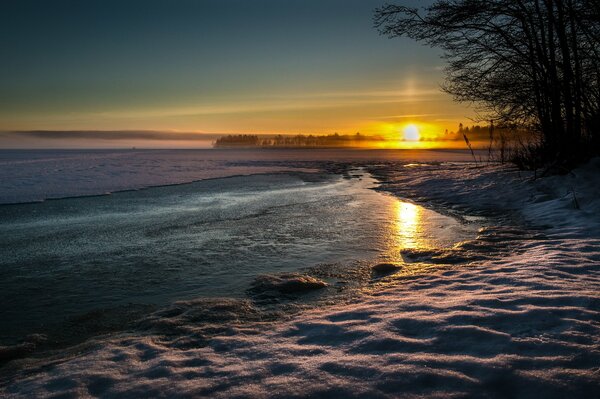 Evening winter sunset with gradually freezing water